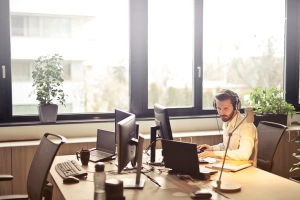 man-with-headphones-facing-computer-monitor-845451